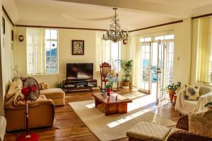 a living room with a couch and a tv at Villa Antoinette in Gros Islet