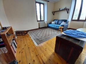 uma sala de estar com um sofá azul e piso em madeira em Duplex dans maison Chez Bastien em Mouxy
