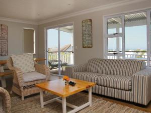 a living room with a couch and a coffee table at Seals Backpackers in Cape St Francis