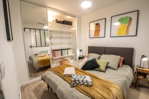 1 dormitorio con 1 cama grande y espejo en T2 cosy et climatisé au cœur de la ville - La Golondrina, en Martigues