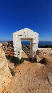 a stone building with an archway in front of the ocean at Alba b&b in Polignano a Mare