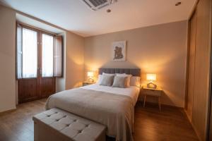 a bedroom with a large bed and two lamps at EREA apartamentos turísticos in Monforte de Lemos