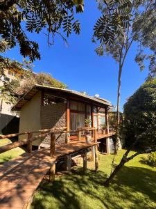a house with a wooden deck in the grass at Pousada Santa Vila in Serra do Cipo