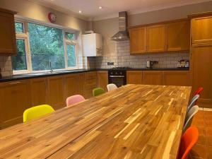 a large wooden table in a kitchen with chairs at Edge view, outdoor adventure focused cottage, sleeps 8 in Bamford