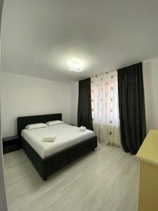 - une chambre avec un grand lit et une fenêtre dans l'établissement SorinaApartament, à Tîrgu Neamţ