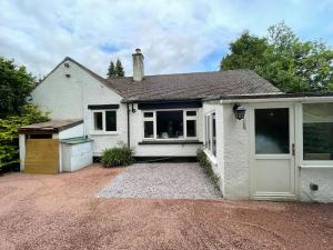 a white house with a driveway in front of it at Edge view, outdoor adventure focused cottage, sleeps 8 in Bamford