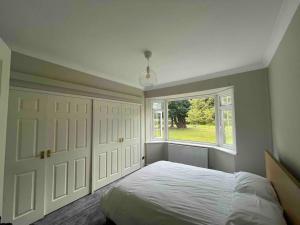 a bedroom with a large bed and a window at Edge view, outdoor adventure focused cottage, sleeps 8 in Bamford