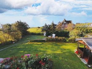 a garden with flowers and a house in the background at Ferienwohnungen Peters in Rantum