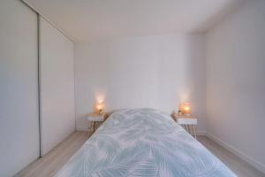 - une chambre avec un lit et 2 bougies sur 2 tables dans l'établissement Charmant Appartement avec Jardin, à Pessac