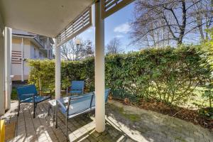 - deux chaises bleues et une table sur une terrasse couverte dans l'établissement Charmant Appartement avec Jardin, à Pessac
