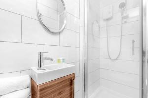 a white bathroom with a sink and a shower at Wolverhampton Luxury Apartment - Free Wifi & Netflix - On Street Parking 12C in Birmingham