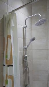 a shower with a shower curtain and a shower head at Bueno Guest hause in Yerevan