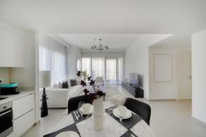 a white living room with a table and chairs at Luxury Apartment in Dubai in Dubai