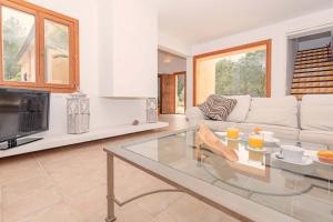 een woonkamer met een bank en een glazen tafel bij Villa Comella in Artá