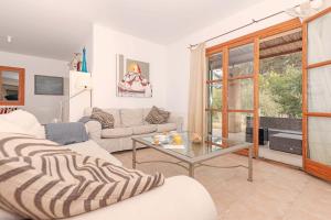 een woonkamer met 2 banken en een glazen tafel bij Villa Comella in Artá