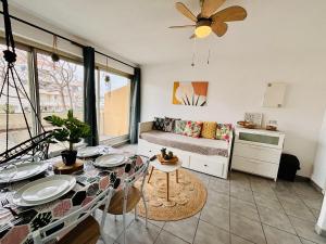 uma sala de estar com uma mesa de jantar e um sofá em Superbe T2 au calme avec balcon sur la marina - 10 em Canet-en-Roussillon