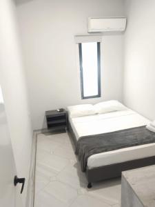 ein weißes Schlafzimmer mit einem Bett und einem Fenster in der Unterkunft Hotel la Carpita in El Poblado