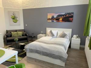 1 dormitorio con cama y sofá en FlatDeCologne CityPerle en Colonia