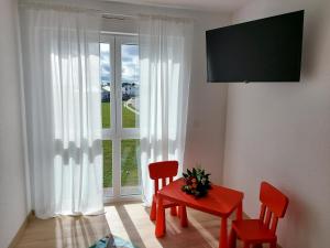 sala de estar con mesa, 2 sillas y ventana en Premium Vulkaneifel Chalet, en Lutzerath
