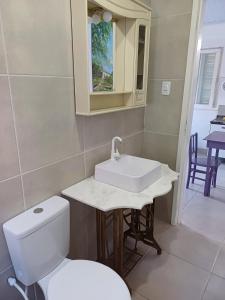 Łazienka z białą toaletą i umywalką w obiekcie Casa do Mato II w mieście São Lourenço do Sul