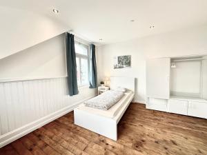 a white room with a bed and a window at Business Apartments Niederbipp ZIMMERzuVERMIETEN in Niederbipp