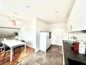 a kitchen with a white table and a white refrigerator at Business Apartments Niederbipp ZIMMERzuVERMIETEN in Niederbipp