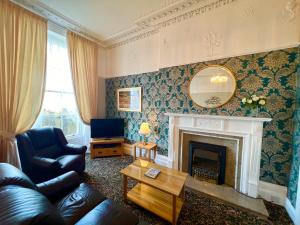 a living room with a couch and a fireplace at Eden Vale Ground Floor Sea View Apartment in Morecambe