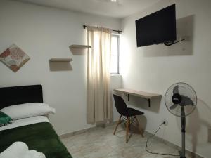 a bedroom with a bed and a desk with a fan at GURUS FR | Cerca al CC Arboleda, Circunvalar y Centro in Pereira