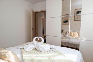 a white bedroom with swans towels on a bed at Bella Vita in Trilj +20 photos