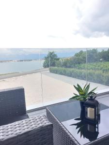 een glazen tafel met een vaas erop met uitzicht op het strand bij Villa Crystal Aenona in Nin