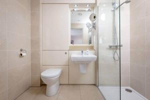 a bathroom with a toilet and a sink and a shower at Kinness House, Luxury Apartment with Parking in St Andrews