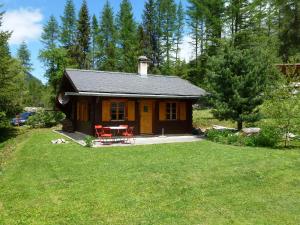 a small cabin with a table and chairs in a yard at Le Bouvreuil Zinal, le VRAI petit chalet de vacances! in Zinal