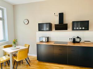 a kitchen with a table and a table and chairs at Apartment FAUNA in Halle an der Saale in Halle an der Saale