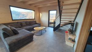 ein Wohnzimmer mit einem Sofa und einer Treppe in der Unterkunft CHALET LE 17 4 étoiles in La Bresse