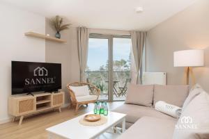 un soggiorno con un divano e una TV di Apartament Lux Sea z dostępem do basenu,saun-Pinea Apartments Pobierowo-SANNEL Apartments for rent a Pobierowo