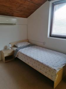 a small bedroom with a bed and a window at Kuća za odmor Ke ti je in Velika Gorica