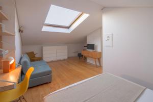 Habitación con sofá, escritorio y tragaluz. en Fil's Place, en Oporto