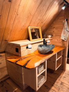 La salle de bains est pourvue d'un lavabo en pierre sur un comptoir en bois. dans l'établissement Ferienhaus Spycher im Emmental, à Lützelflüh