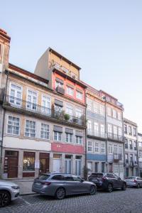 Un gran edificio con coches aparcados delante. en Fil's Place, en Oporto
