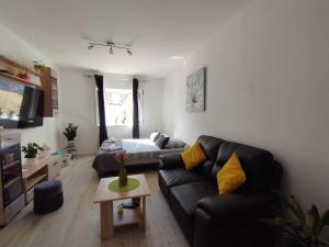 a living room with a black couch and a table at Anne in Komiža