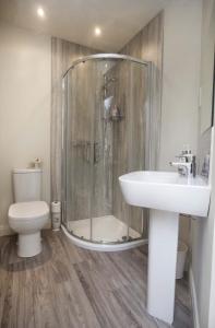 a bathroom with a shower and a sink and a toilet at Linton Court Coach House in Settle +36 photos