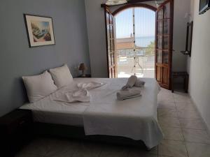 a bedroom with a bed with towels on it at Dora Studios in Parga