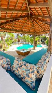 eine Terrasse mit blau gepolsterten Stühlen unter einem Pavillon in der Unterkunft Hotel Pousada 360 in Paracuru