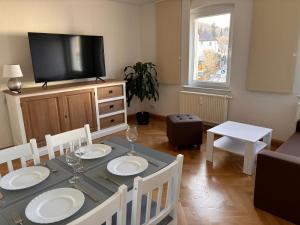 a dining room with a table and a television at Ferienwohnung Freital-City in Freital