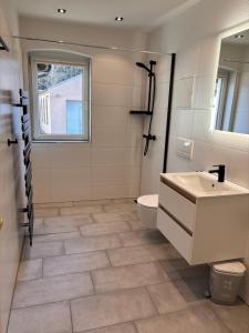 La salle de bains est pourvue d'un lavabo, de toilettes et d'une fenêtre. dans l'établissement Ferienwohnung Freital-City, à Freital