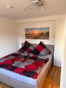 a bedroom with a bed with red and black blankets at Ferienwohnung Freital-City in Freital