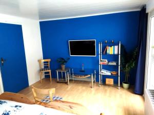 a blue room with a table and a tv on a wall at Ferienhaus Loreleytal in Boppard