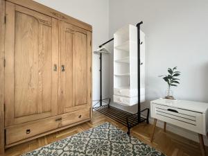 Pokój z dużą drewnianą szafką i biurkiem w obiekcie BpHomes w Budapeszcie