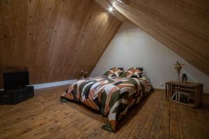 een slaapkamer met een bed en een houten plafond bij La Nuit Des Héros in Sainte-Mère-Église