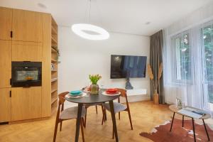 uma sala de estar com uma mesa e cadeiras e uma televisão em Buen Home Apartments - Old Town em Rzeszów